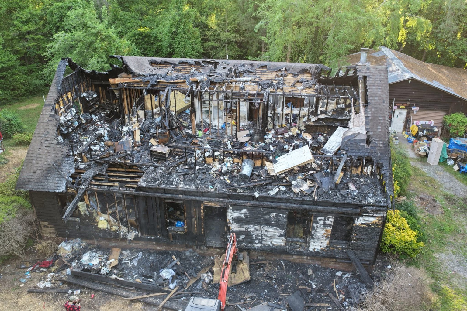 Front aerial view of a fire-damaged house during demolition