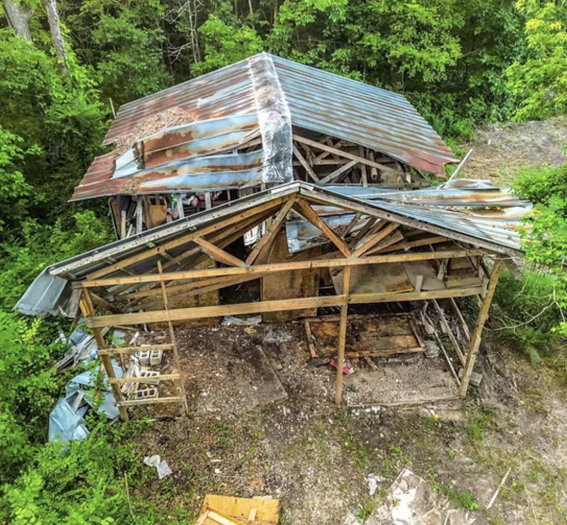 Aerial view of a partially dismantled outbuilding with a metal roof